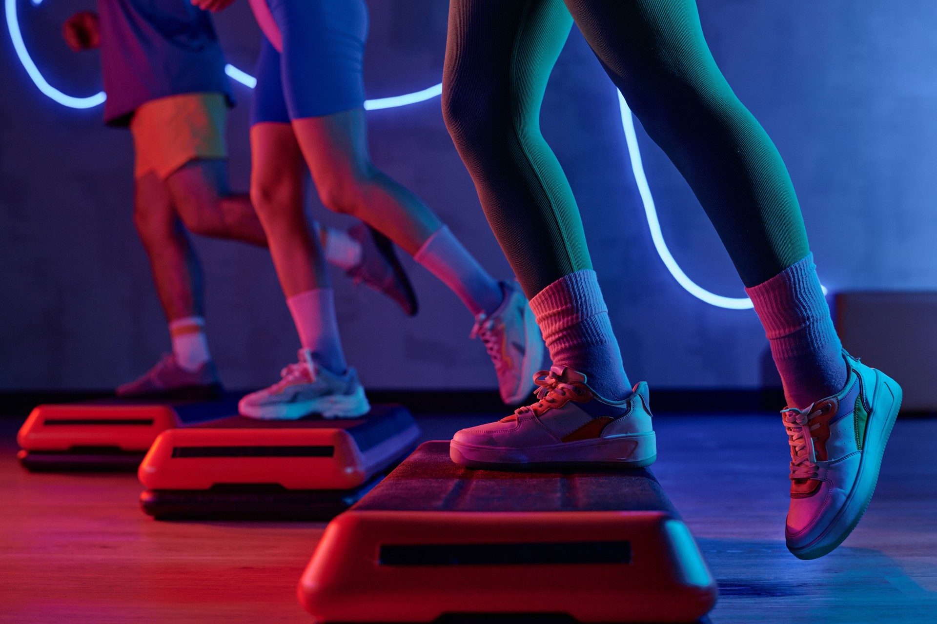 People Doing Workout on Step Platforms in Exercise Room